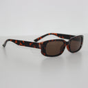 Tortoiseshell Robusto safety glasses with clear side shields, viewed from the side on a white surface